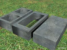 two concrete blocks sitting on top of a grass covered field next to each other in the shape of squares and rectangles