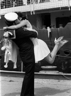 a man and woman dance on the deck of a ship while holding each other in their arms