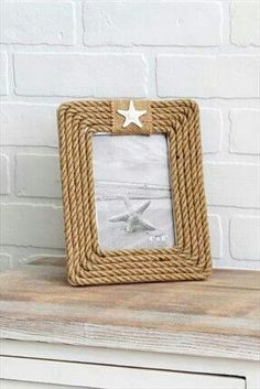 a photo frame sitting on top of a wooden table next to a white brick wall