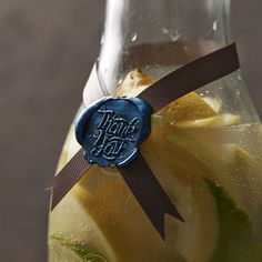 a close up of a bottle of liquid with a ribbon around the neck and label that says, thank you