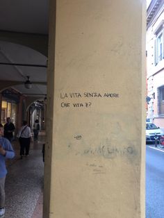 graffiti on the side of a building that says la vita santa anade, give with e?