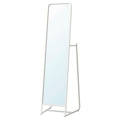 a white standing mirror on a metal stand