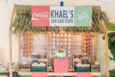 a table topped with a cake covered in frosting next to a sign that says khale's safari store