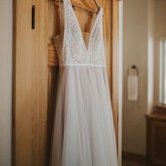 a white dress hanging on a wooden door