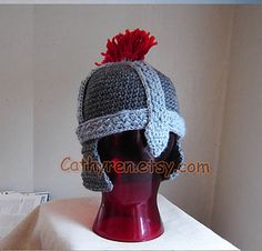 a crocheted hat with a red flower on top of a mannequin head