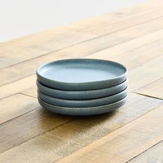 three plates stacked on top of each other on a wooden floor with white walls in the background