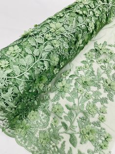 an image of green fabric with flowers and leaves on white background in close up view