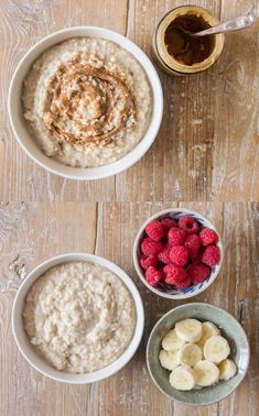 oatmeal with raspberries, bananas and peanut butter in bowls on a wooden table