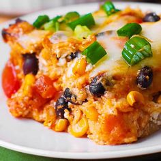 a white plate topped with lasagna covered in cheese and vegetables