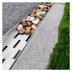 some rocks and grass on the side of a road with a ramp going down it