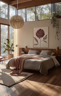 a bedroom with wooden floors and large windows overlooking the trees in the distance is shown