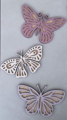 three butterflies cut out of paper on top of a piece of paper