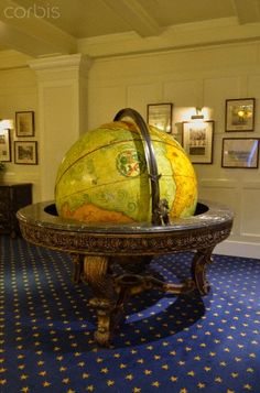 a large yellow globe sitting on top of a table in a room with blue carpet