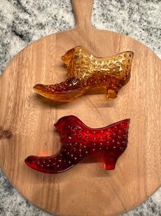 three pieces of glass sitting on top of a wooden cutting board next to each other