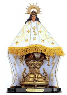 a statue of the virgin mary in gold and white