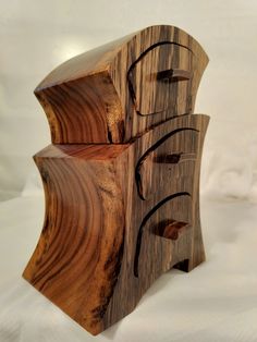 a wooden object with several pieces of wood carved into it's sides and the top