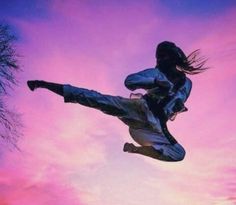 a person jumping in the air on a skateboard at sunset or dawn with pink clouds behind them