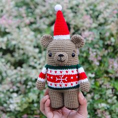 a crocheted teddy bear wearing a christmas sweater