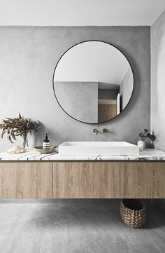 a bathroom with a large round mirror above the sink