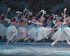 the snowflakes are falling on the dancers