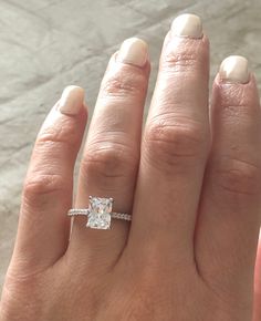 a woman's hand with a engagement ring on it and a diamond in the middle