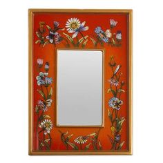 an orange frame with flowers painted on the side and a mirror in front of it