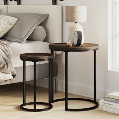 two end tables sitting next to each other on a wooden floor in front of a bed