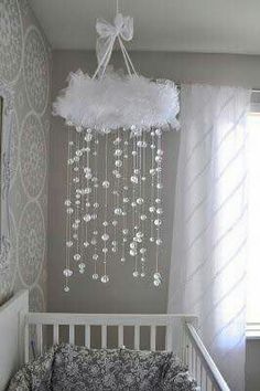 a white crib with a chandelier hanging from the ceiling