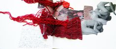 an open book with red yarn and pictures on it