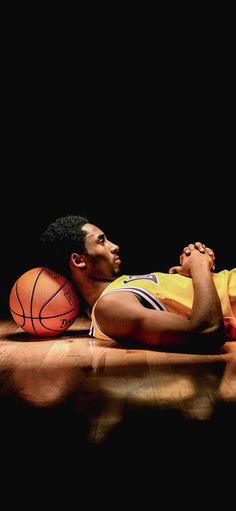 a man laying on the floor with a basketball