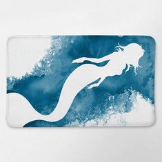 a blue and white mouse pad with a silhouette of a mermaid in the ocean on it