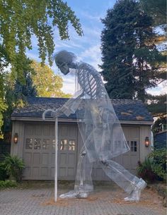 a skeleton statue in front of a garage