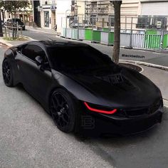 a black sports car is parked on the street