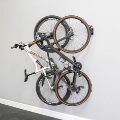 two bikes are hanging on the wall with wheels attached to it's back end