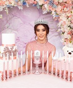 a woman sitting in front of a cake with candles