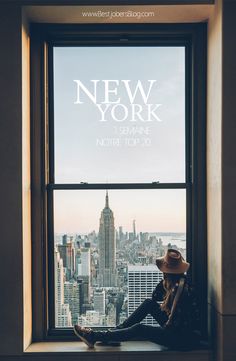 a person sitting on a window sill looking out at the city