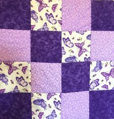 a purple and white quilt with butterflies on it