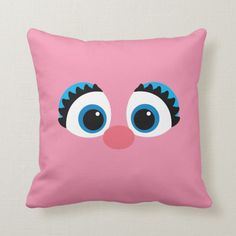 a pink pillow with blue eyes on it