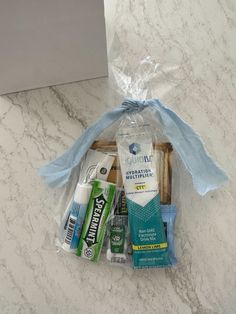 the contents of a personal care kit are wrapped in plastic and tied with a blue ribbon