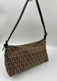 A stunning Fendi Pochette shoulder bag. Made in the classic Fendi beige/brown Zucca Canvas. Brown leather top handle and Fendi branded silver hardware. Inside there is an internal slip pocket for your valuables. This bag is in great condition with minor signs of wear. The hardware has slight scratches. The external canvas has one small stain (is pictured). Lining is strain free. The leather straps show some slight signs of wear in the form of a few creases. Fendi Pochette, Vintage Fendi Bag, Brown Leather Top, Vintage Fendi, Bottega Veneta Shoulder Bag, Fendi Bags, Beige Brown, Prada Bag, Bag Tags