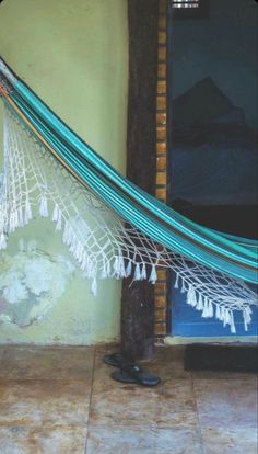 a hammock hanging from the side of a building next to a door and window