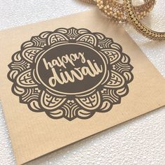 a card with the words happy diwal on it next to a pair of gold bracelets