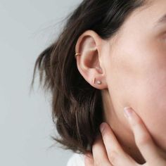 a close up of a person wearing a pair of ear piercings on their ears