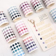 several rolls of washi paper with polka dots on them next to a note and pen