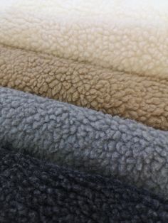 four different colored blankets are stacked on top of each other in this close up photo