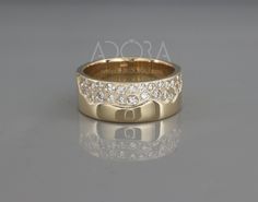 a gold wedding band with diamonds on the side and an inscription that reads asocca