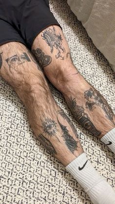 a man laying on the floor with his legs covered in tattoos and socks that have animals all over them