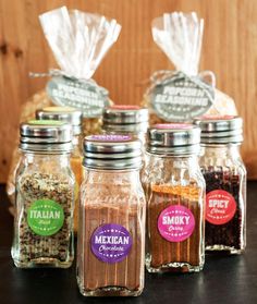 four jars filled with spices sitting on top of a table