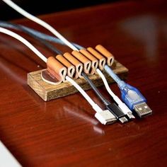 an electronic device connected to a laptop on a wooden table next to a white keyboard