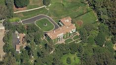 an aerial view of a large house in the middle of some trees and grass area